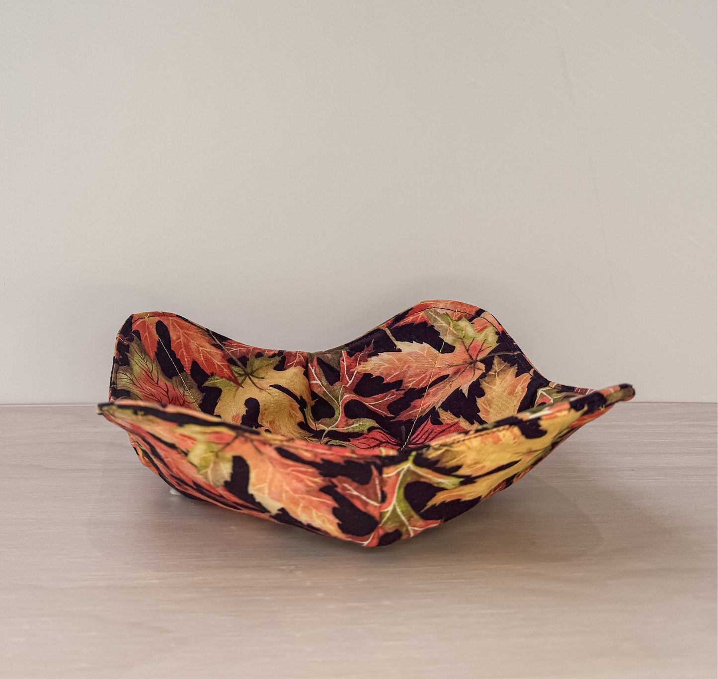 Brilliant orange red and gold leaves on a black background bowl cozy