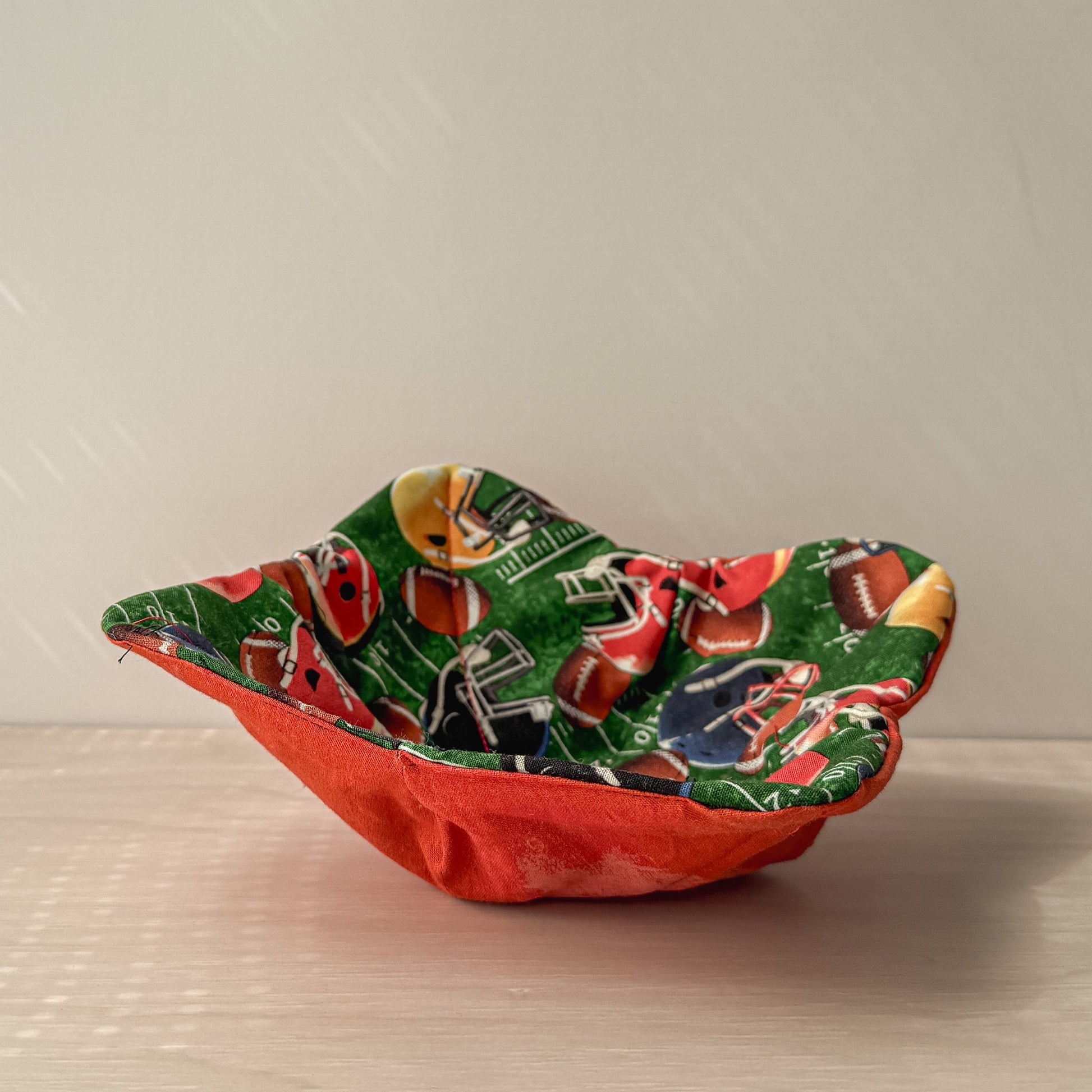 Football helmet bowl cozy on a neutral background