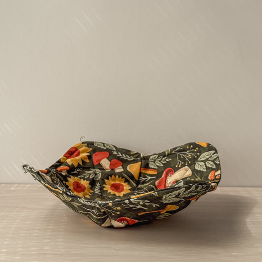 Decorative bowl with green mushroom floral pattern on a neutral background